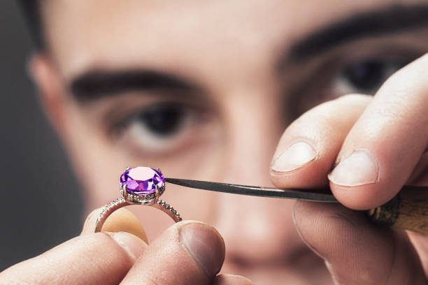 Jewelry master examines the gold ring for defects, close-up stock photo