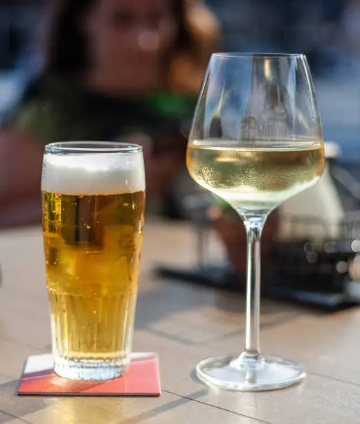 Close up van een glas wijn en een biertje
