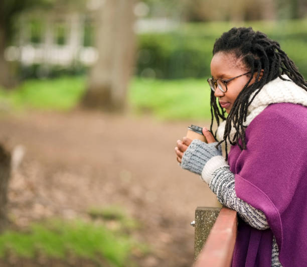 秋に橋のそばに立つ - braids african descent women pensive ストックフォトと画像