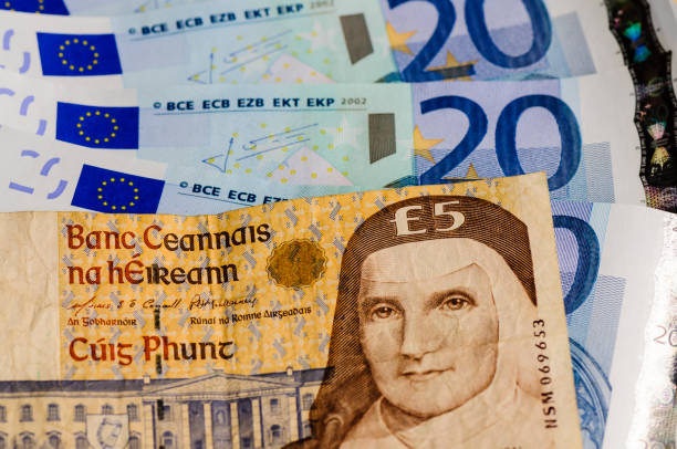 Irish £5 five punt bank note against a number of Euro notes Irish £5 five punt bank note against a number of Euro notes irish punt note stock pictures, royalty-free photos & images