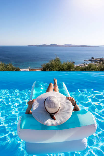 la femme flotte sur une piscine et apprécie la vue à la mer - sea swimming greece women photos et images de collection