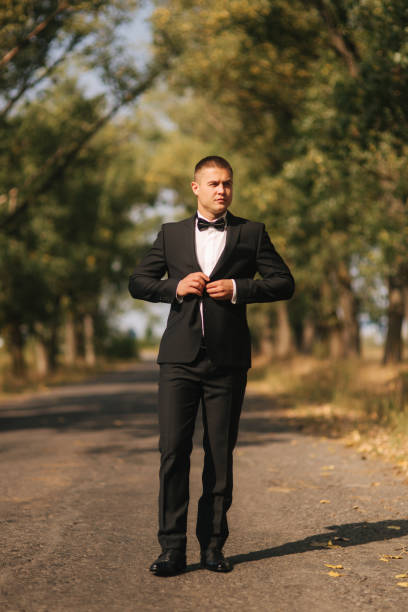 istock Young man walking in the park. Handsome groom in black suit 1164007149