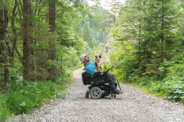 man on electric wheelchair using mirrorless camera nature, enjoying freedom and doing art
