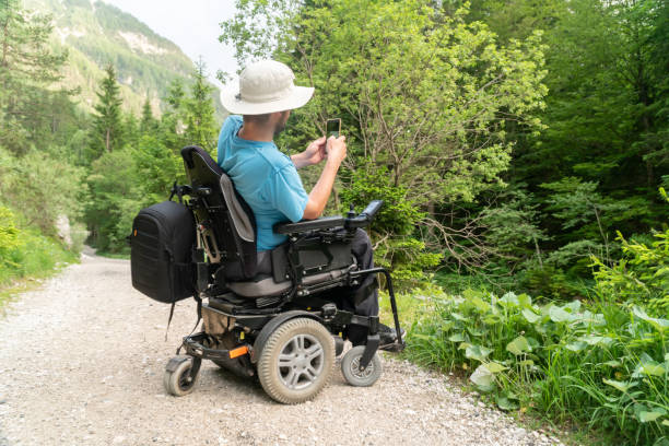 istock man on electric wheelchair using smartphone camera in nature 1164009802