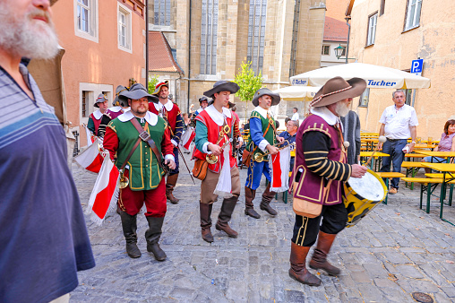 Local folk artists are performing for tourists. Famous old town cityscape at Rothenburg ob der Tauber, Germany.