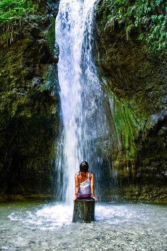 Woman under waterfall.