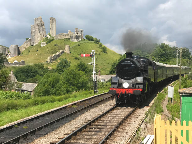 英国のコーフェ城の町に到着する蒸気機関車 - corfe castle ストックフォトと画像