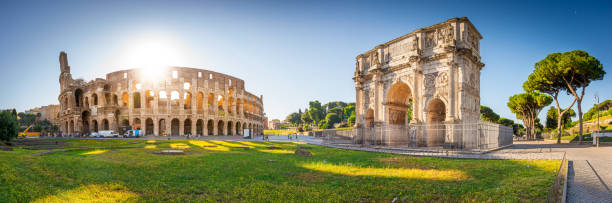 panorama du colisée et de l'arc de constantin au lever du soleil à rome, italie, europe. - gladiator rome italy sunlight photos et images de collection