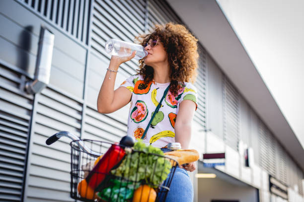 idratazione durante l'estate. una giovane donna beve acqua - water bottle healthy eating water bottle foto e immagini stock