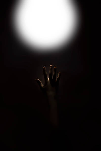 istock hand reaching up to touch a glowing light 1164017328