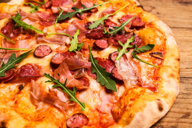 istock Hot pizza slice with melting cheese on a rustic wooden table. 1164019241