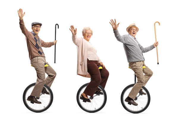 personnes âgées conduisant des monocycles et souriant à l'appareil-photo - unicycling photos et images de collection