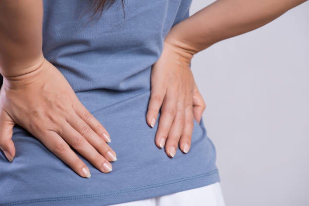 nahaufnahme frau mit schmerzen im verletzten rücken. gesundheits- und rückenschmerzkonzept. - inflammation back physical therapy isolated on white stock-fotos und bilder