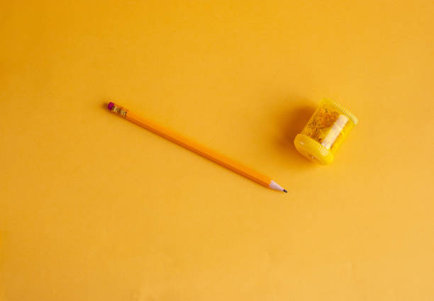 istock Bright yellow pencil with a sharpener for studying, drawing, hobby on a yellow background. With space for copy space. 1164021900