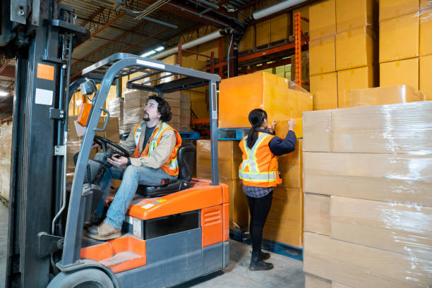 istock An industrial warehouse workplace safety topic. A worker in the danger zone, working behind a forklift carrying a load. 1164022424