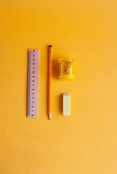 istock Bright yellow pencil with sharpener, wooden ruler and eraser for studying, drawing, hobby on a yellow background. 1164022712