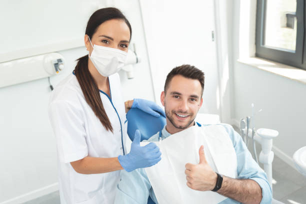 istock Young doctor dentist and patient showing thumb up 1164023823