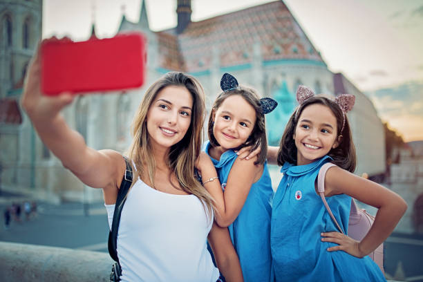 istock Mother and her daughters are hugging and taking selfie/making video call 1164025552