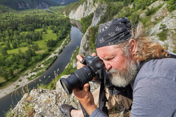 istock Mature man photographs nature. 1164025646