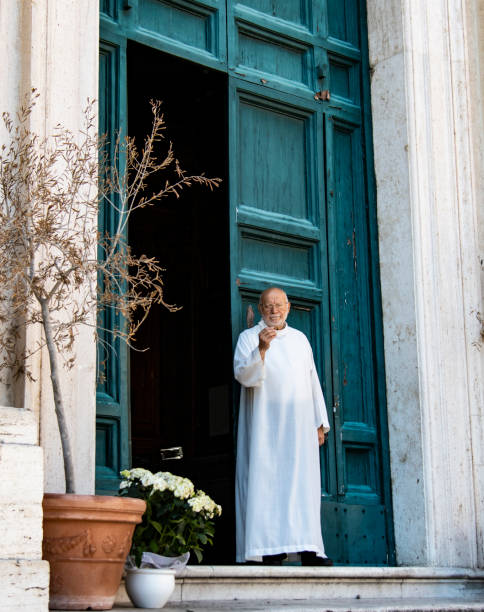 Priest in Rome, Italy in front of catholic church stock photo