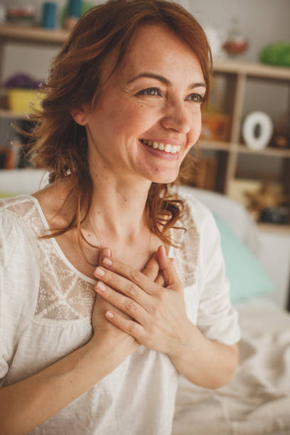 istock Excited woman smiling and holding hands on her chest 1164032733
