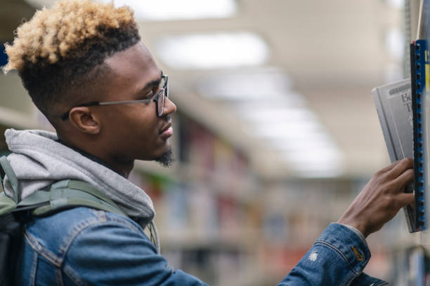 istock University Male of African Descent finding a book 1164033298