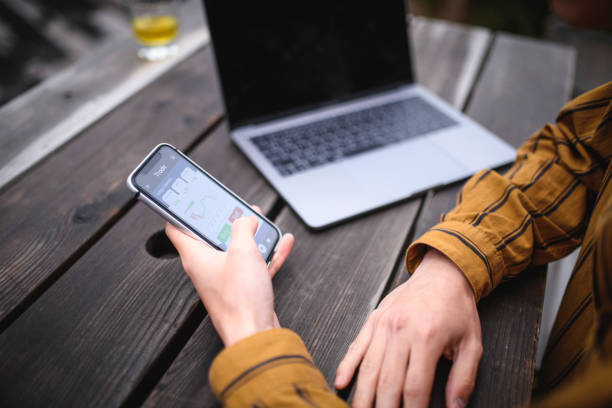 istock Young Japanese Man Using Investment Mobile App Outdoors 1164033409