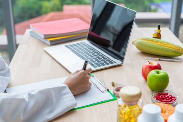 아시아 영양사 의사 여자 쓰기 및 나무 테이블에 실험실 꼭대기 - genetic research chemist writing science 뉴스 사진 이미지