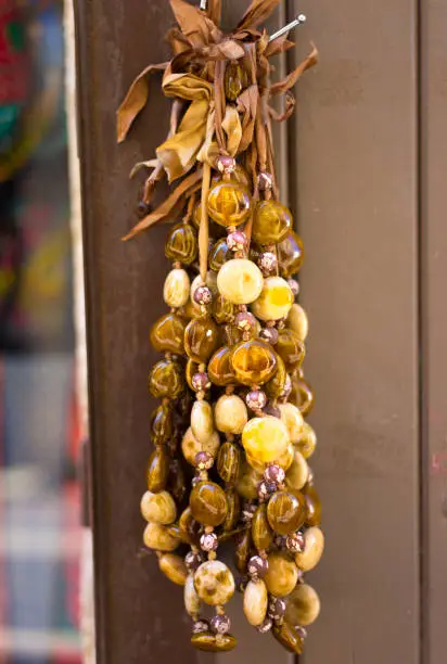 Amber necklaces hanging on a brown wood door.