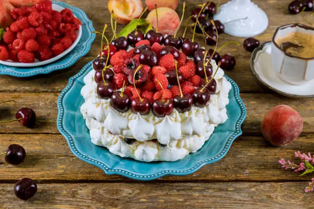Photo of Meringue cake with berries and a cup of coffee