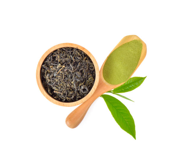 istock Green tea powder and dried leaves on white background 1164047532
