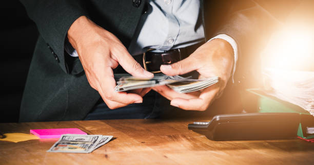 istock Asian Businessmen count money and plan finances for projects and use calculators for analysis project documents and graph financial diagram working in the background on office table 1164054764