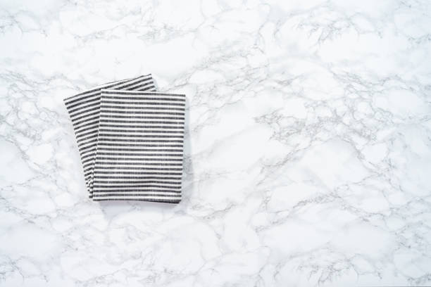 istock Kitchen towels with white and black stripes on the marble counter. 1164054968