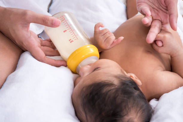 istock Mother feeding newborn baby from milk bottle 1164056026