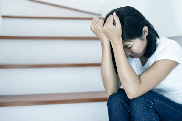 istock The depression woman alone sitting on staircase. 1164058075