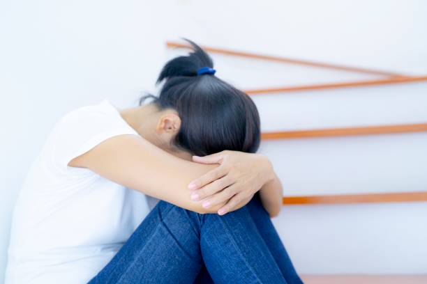 istock The depression woman alone sitting on staircase. 1164058130