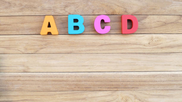 istock Colorful Letter 'A B C D ' on Wooden Table For Beginning English Language 1164061094