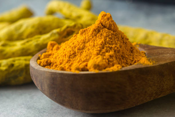 istock Turmeric roots and powder in wood spoon 1164063914