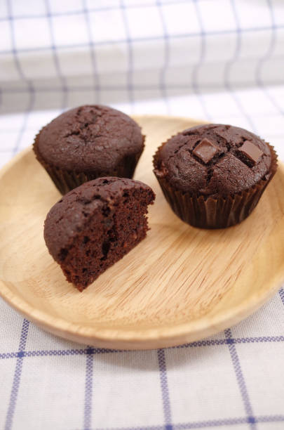 istock Homemade Chocolate Cupcake and Half One on Wooden Plate 1164065452