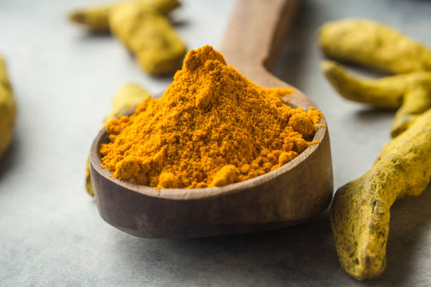 istock Turmeric roots and powder in wood spoon 1164067251