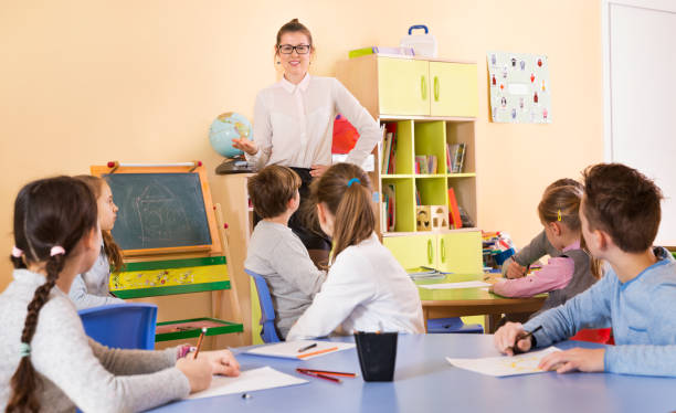 istock Teacher standing at blackboard in classroom 1164075424
