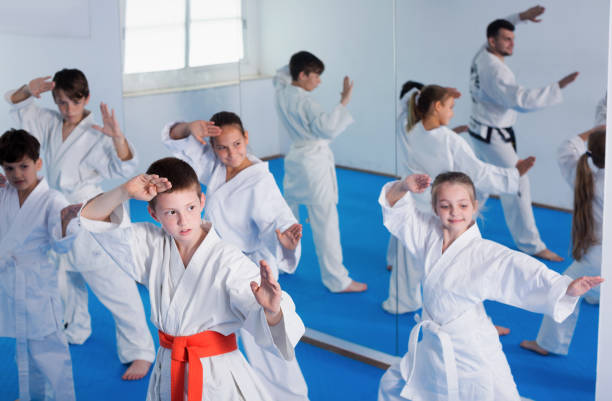 istock Group of young children doing karate kicks 1164076190