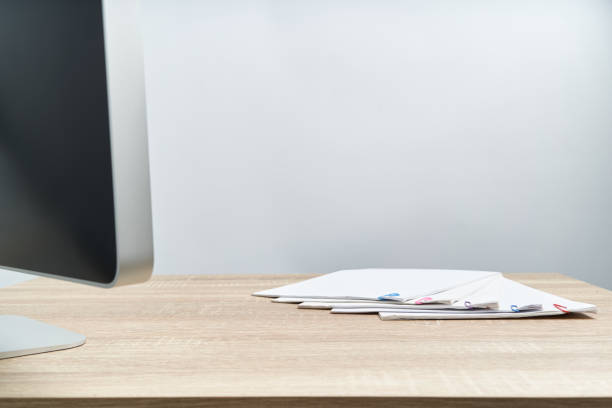 istock Busy paperwork report and computer on wooden table 1164076555