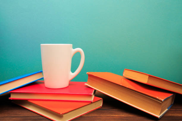 istock pile of old books with mug , panorma, good copy space  on blue background - Image 1164083376