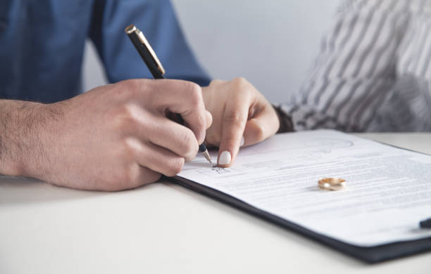 istock Couple with divorce contract and ring on desk. Divorce 1164084137