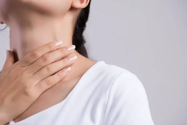 Photo of Sore Throat. Closeup Of Beautiful Young Woman Hand Touching Her Ill Neck. Healthcare and medical concept.