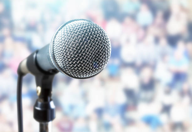 istock Close-up microphone in front of defocused people 1164091535