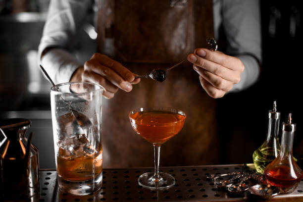 istock Close-up of an olive on skewer in bartender's hands 1164092501