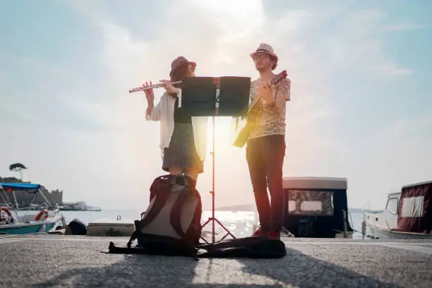 Photo of Flutist and her guitarist friend are playing on the street