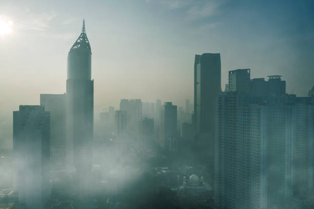 Skyscrapers with air pollution in Jakarta city JAKARTA - Indonesia. April 24, 2019: Aerial view of skyscrapers with air pollution at morning time in Jakarta city jakarta stock pictures, royalty-free photos & images